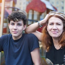 A beautiful woman with a teenage son resting in the summer in the city, happy because they resolved all of the teens' problems