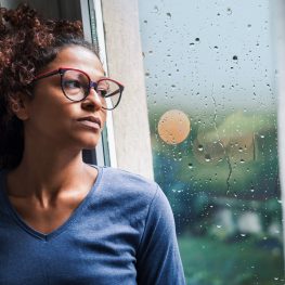 Lonely black woman near window thinking about something