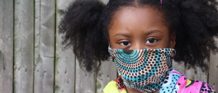 Girl Wearing Cloth Face Mask outside wooden fence background